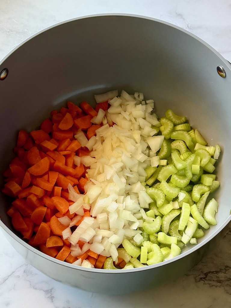 Onions, carrots, and celery sautéed with olive oil in a soup pot.