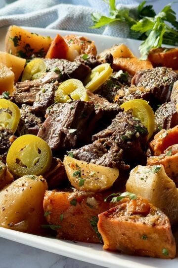 Slow cooker pot roast plated with sweet and russet potatoes.