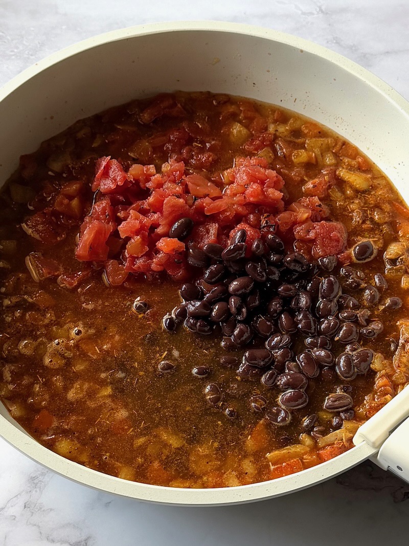 Fire roasted tomatoes, chicken broth, and black beans added to the veggies and spices. 