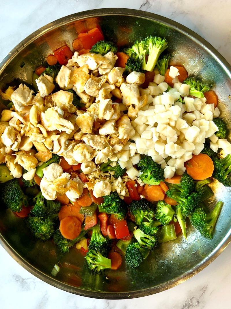 Veggies, chicken, water chestnuts and sauce in a skillet
