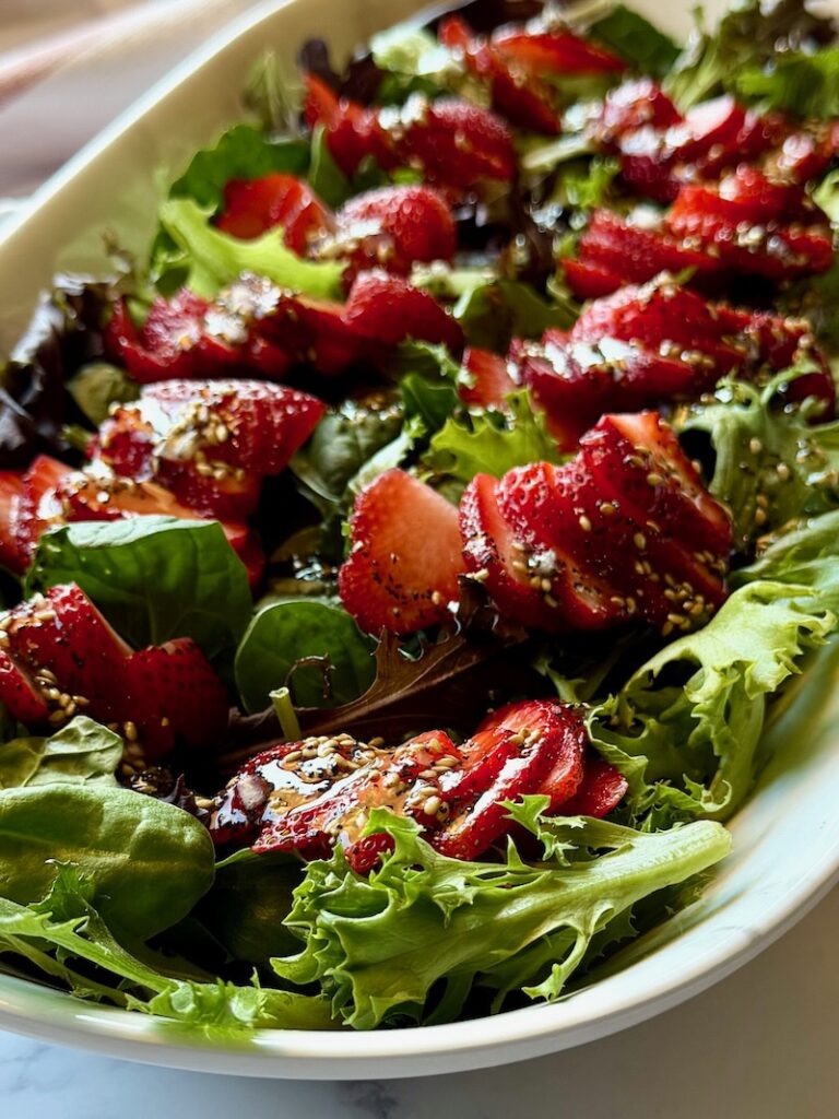 Strawberry salad with poppy seed dressing on top.