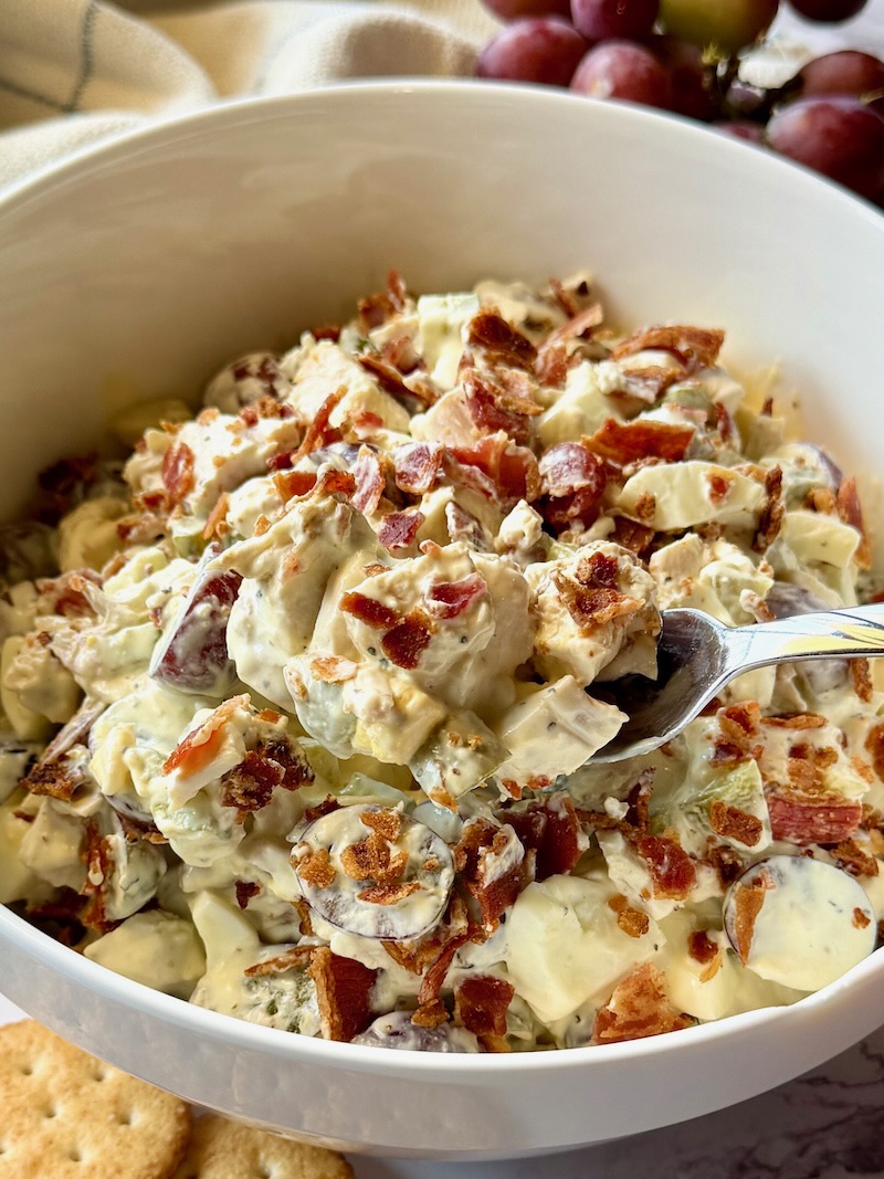 Chicken salad with bacon with a spoon
