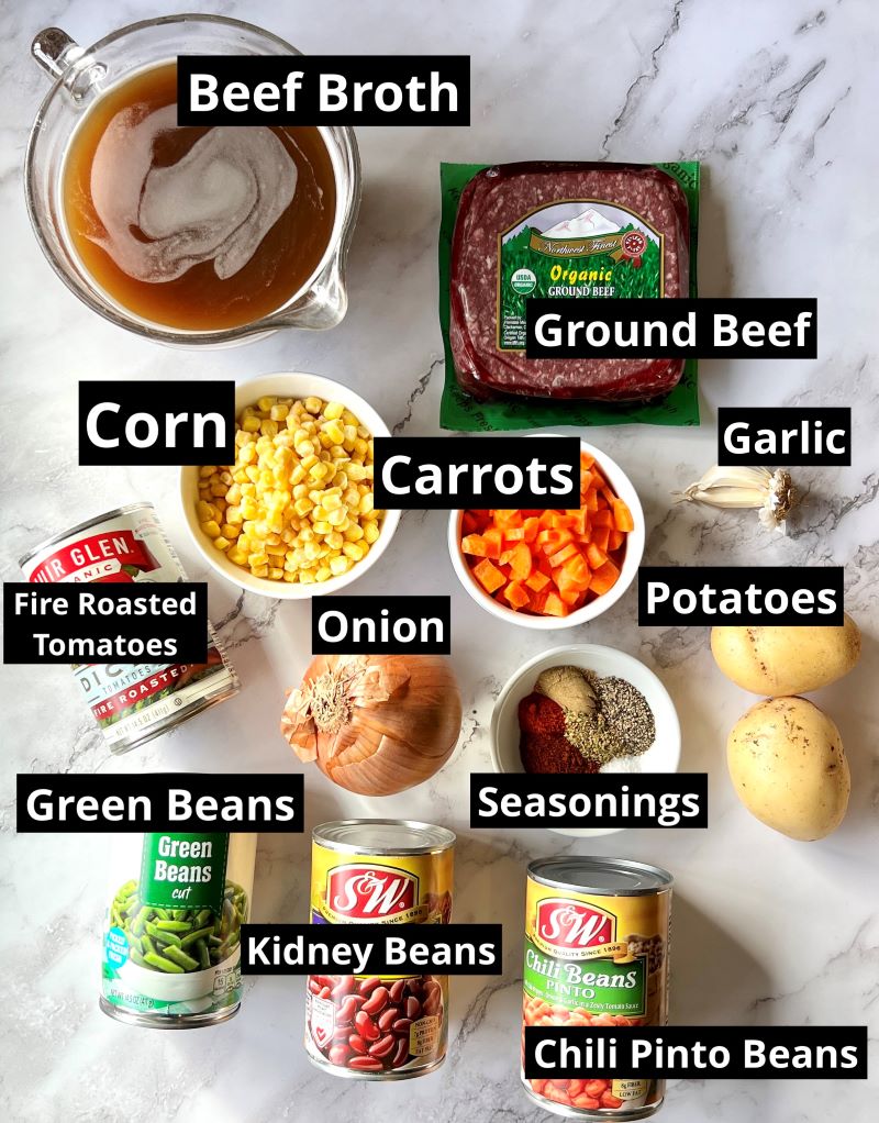 Ingredients for slow cooker cowboy soup. Ground beef, onions, garlic, carrots, corn, potatoes, pinto beans, kidney beans, green beans, spices, fire roasted tomatoes, and beef stock. 