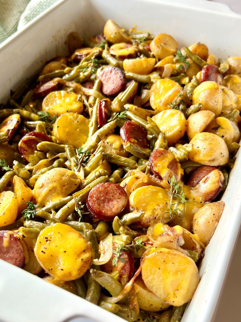 Smoked sausage combined with onions, garlic, seasonings, potatoes, canned green beans and cheese in a casserole dish, baked. 
