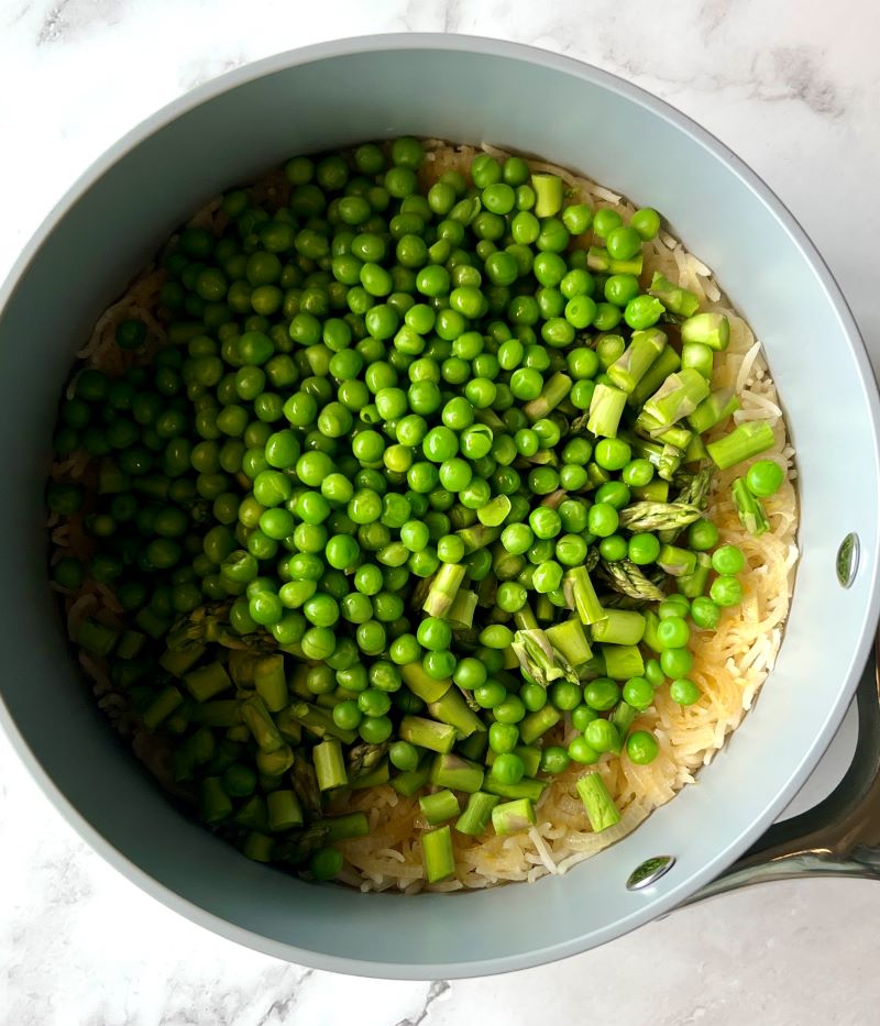 Fresh asparagus and peas added to the cooked rice.