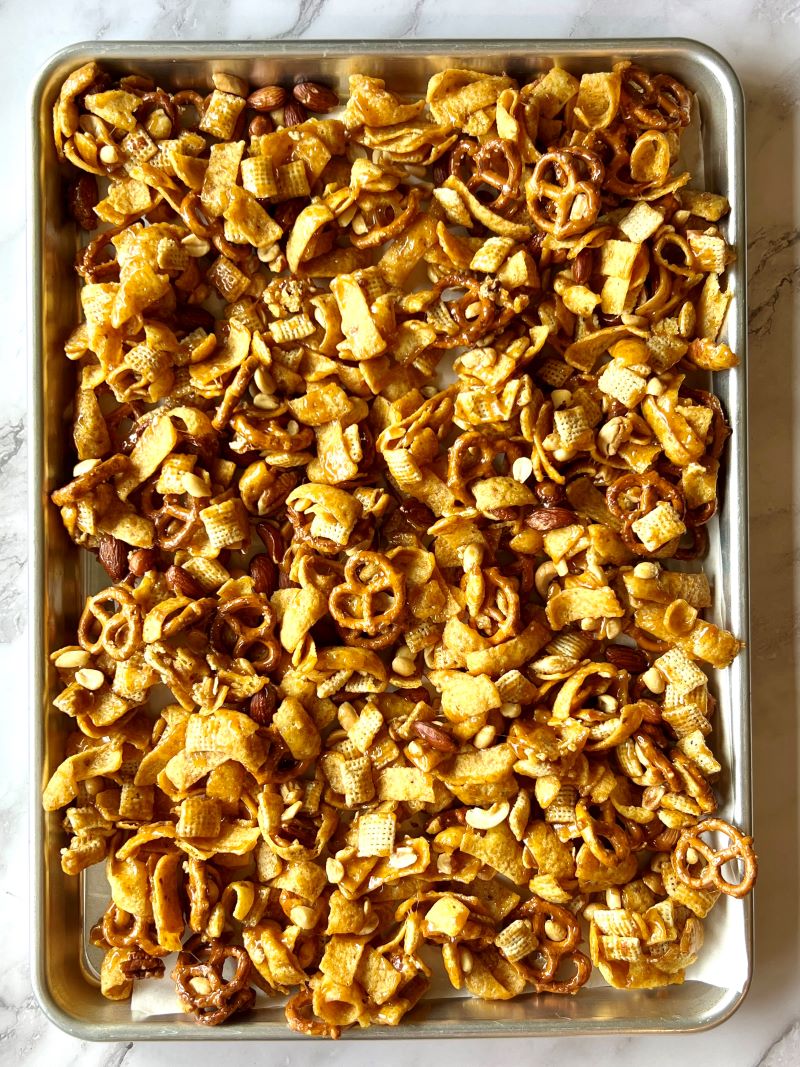 Glaze mixed with crunchy ingredients and spread on a sheet pan.