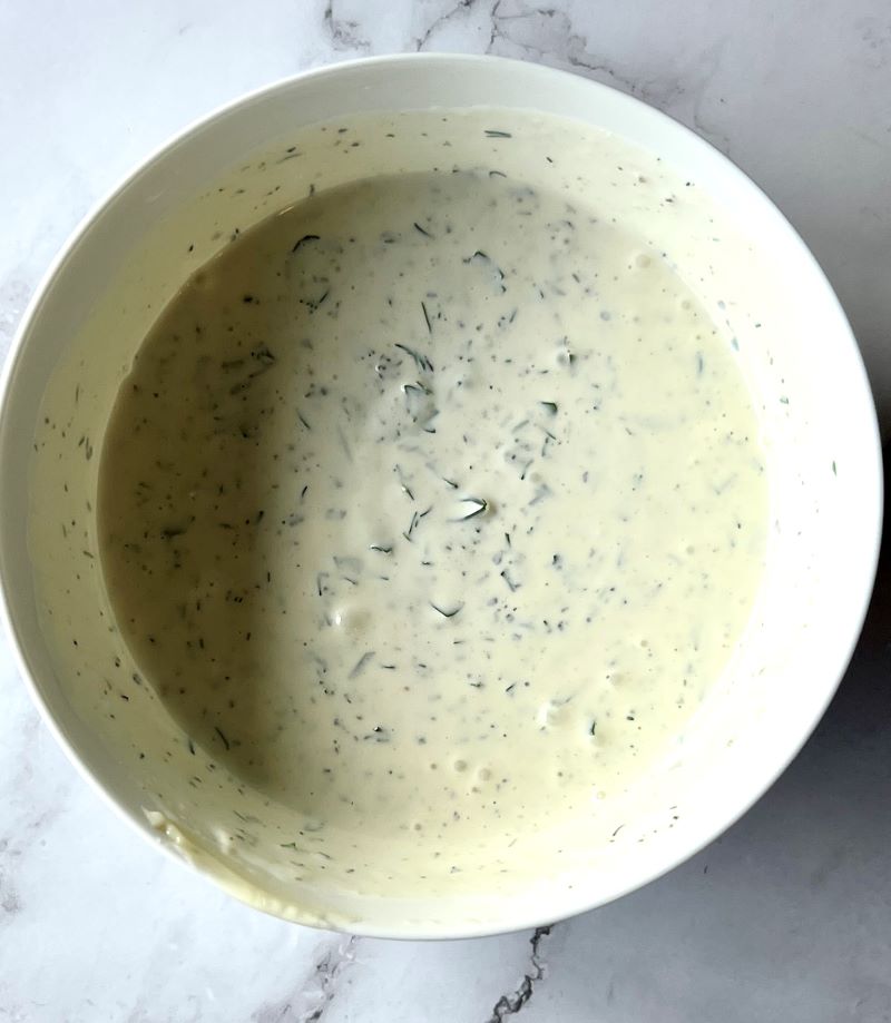 Buttermilk ranch dressing combined in a small bowl. Mayo, sour cream, buttermilk, fresh dill and parsley, garlic powder, onion powder, salt, and pepper. 