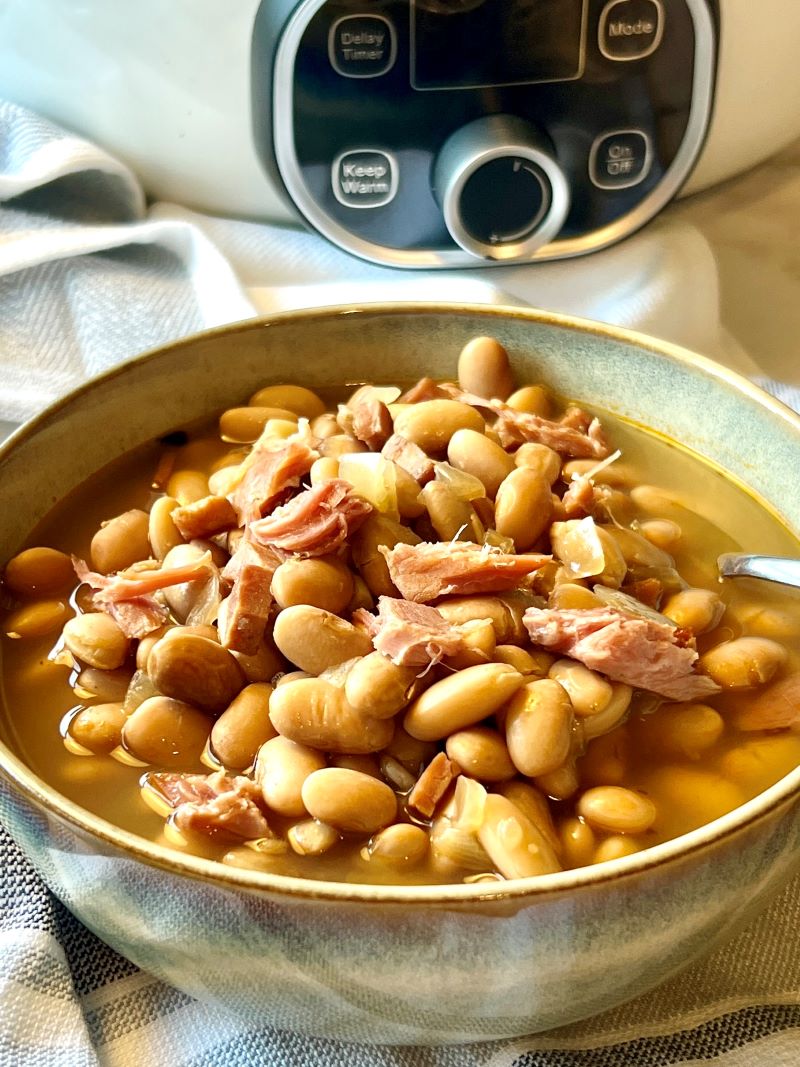 Bowl of ham and beans with a spoon.