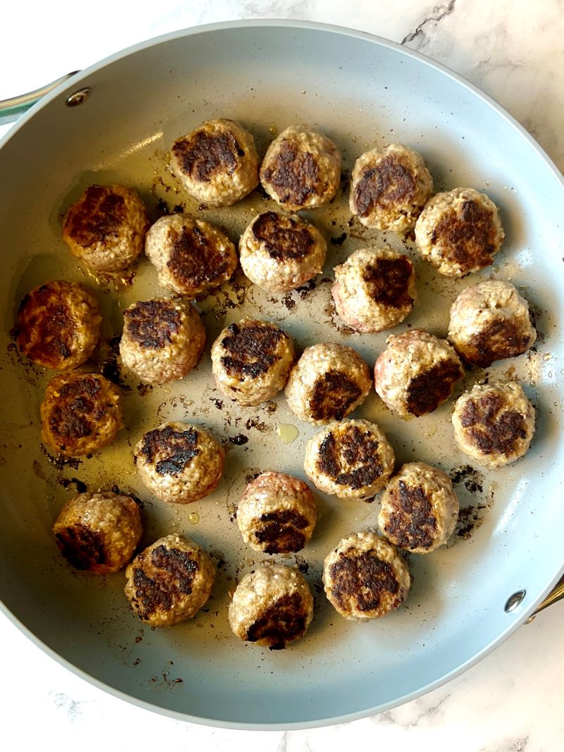 Brown meatballs in a large skillet.
