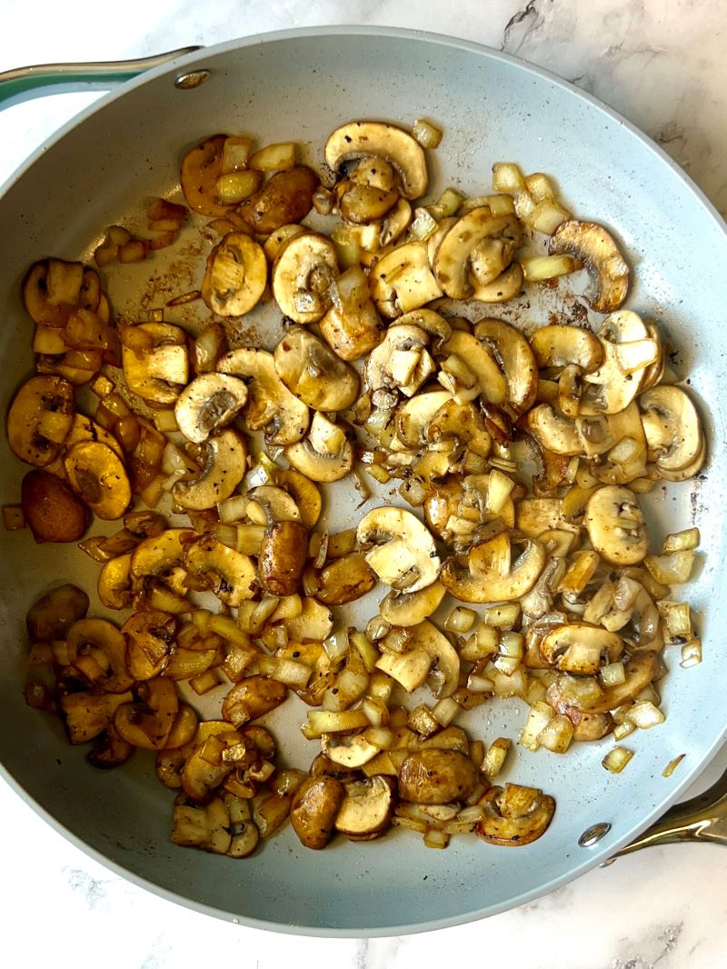 Cooked mushrooms and onions in a large skillet. 