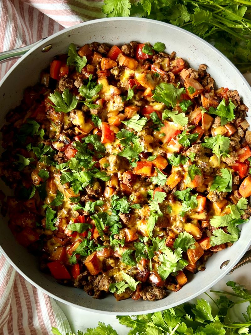 Southwest ground beef sweet potatoes complete with melted cheese and cilantro to garnish.