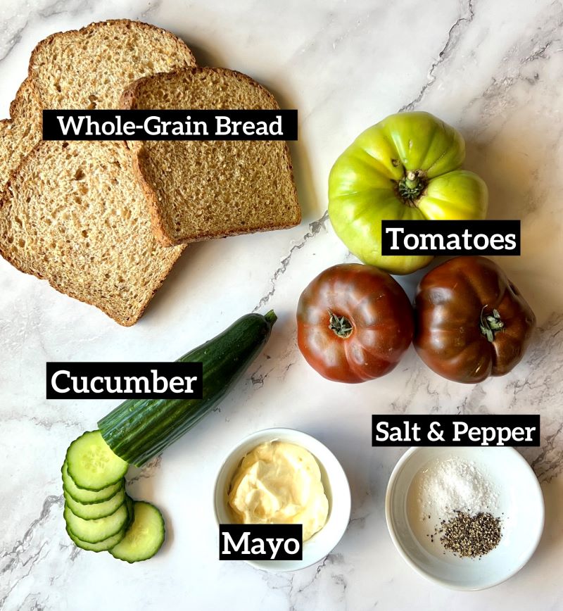 Ingredients set out for tomato and cucumber sandwich. Whole grain bread, tomatoes, cucumbers, mayo, salt and pepper.