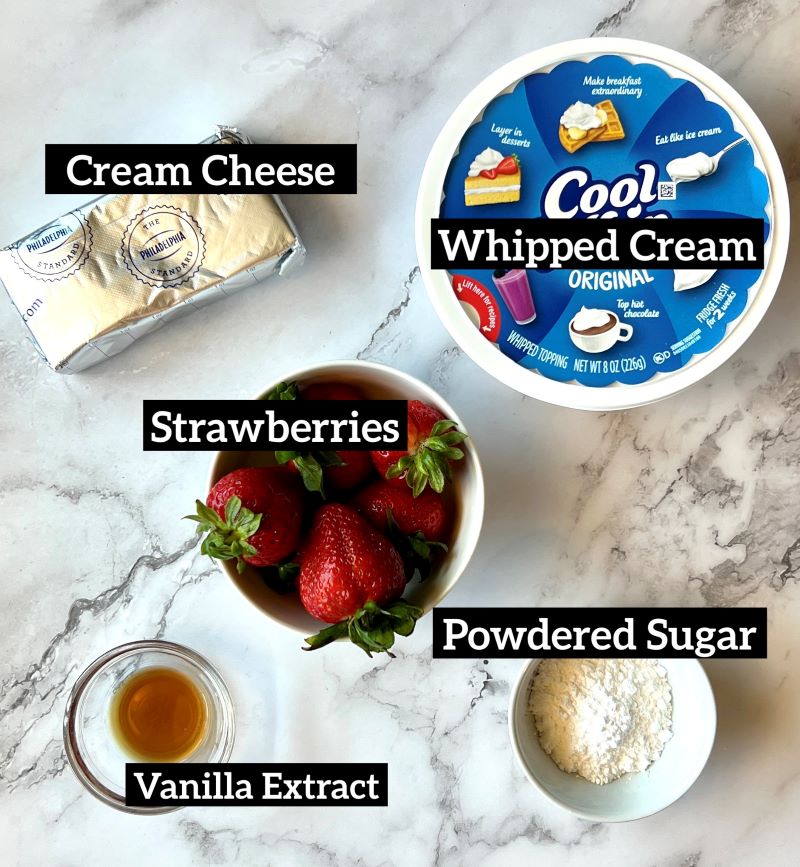 Ingredients displayed for strawberry cream cheese dip. Philadelphia cream cheese, cook whip in a tub, fresh strawberries, powdered sugar, and vanilla extract. 
