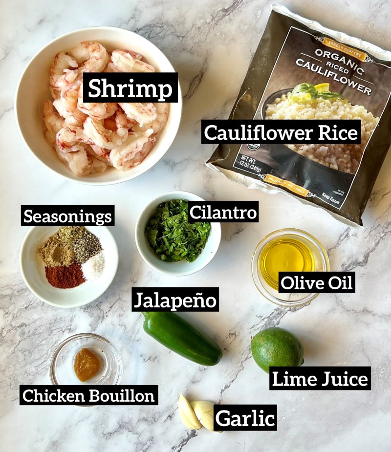 Ingredients set out for the shrimp bowls. Raw shrimp, frozen cauliflower rice, seasonings, cilantro, olive oil, jalapeno, lime juice, garlic, chicken bouillon.