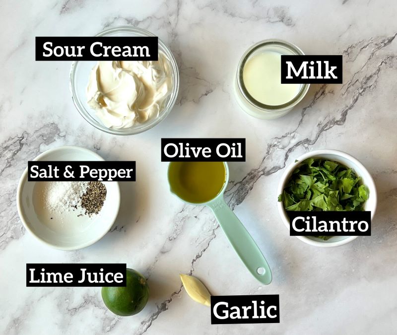 Ingredients set out for cilantro dressing. Sour cream, milk, olive oil, garlic, lime juice, salt and pepper.