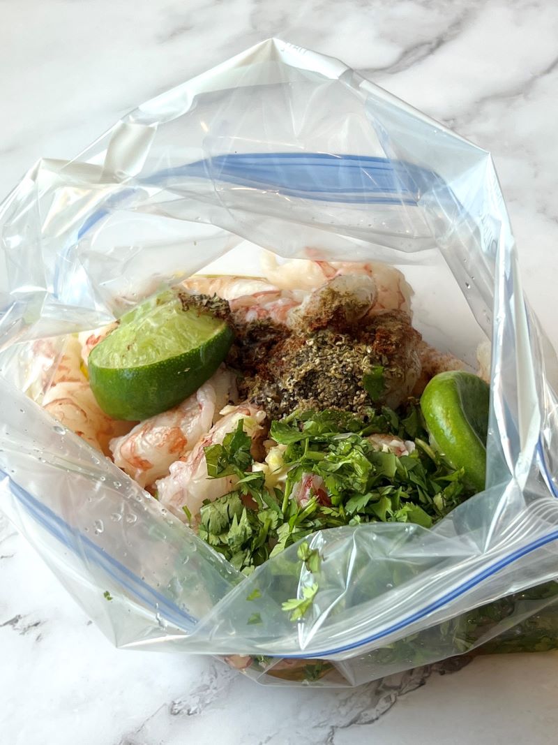 Raw shrimp in a sealable bag with marinade.