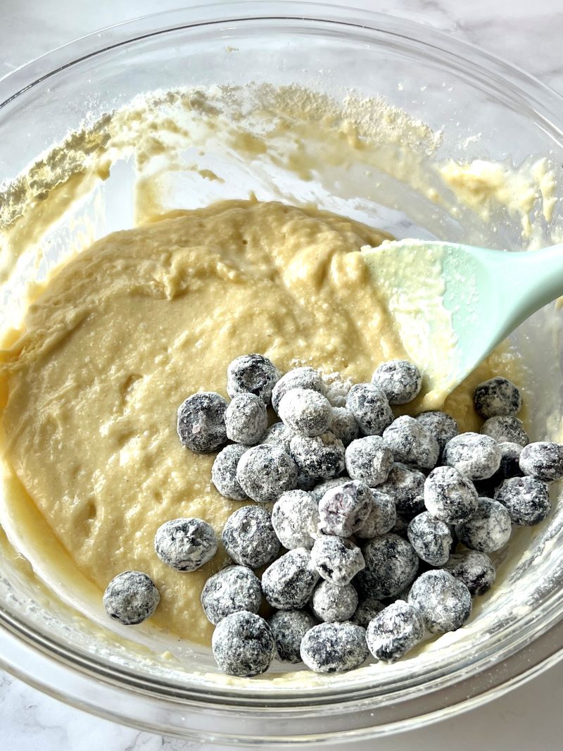 Dry ingredients combined with wet ingredients, buttermilk, and frozen blueberries. 