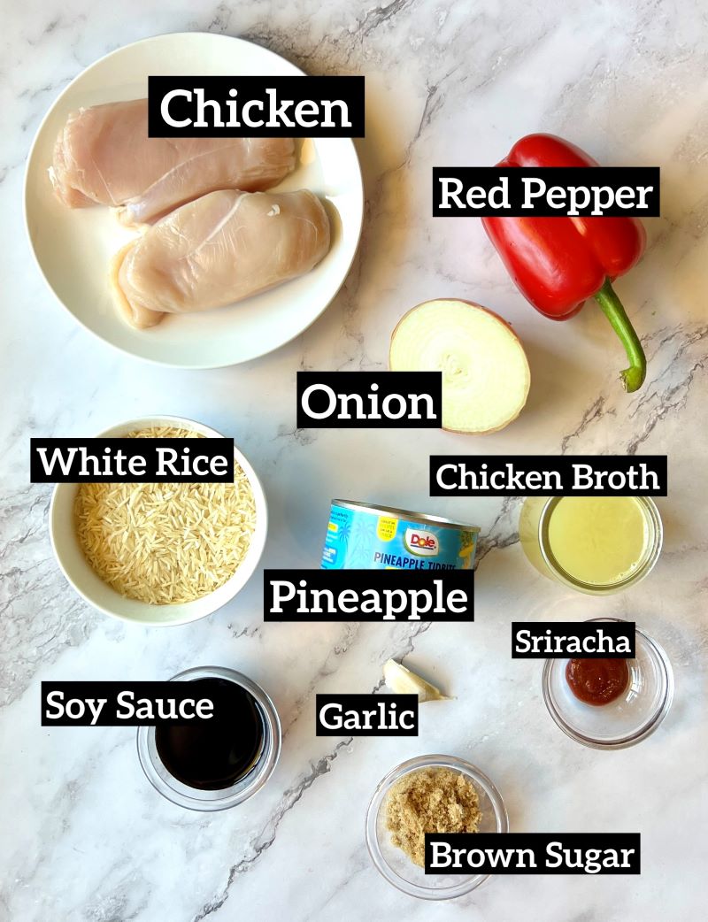 Ingredients displayed for pineapple chicken and rice casserole. Two small Boneless skinless chicken breast, red bell pepper, onion, white rice, pineapple in a can, chicken broth, Sriracha, soy sauce, garlic, brown sugar