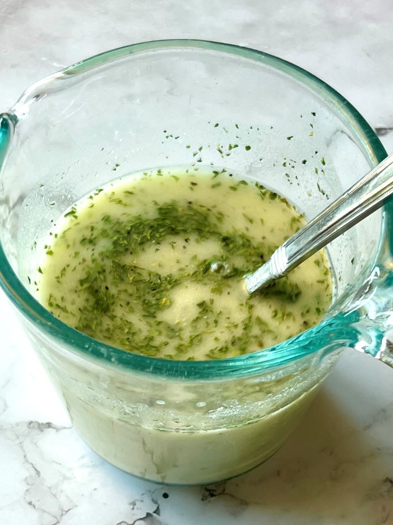 chicken broth, flour, lemon juice, and seasonings combined in a small measuring cup. 