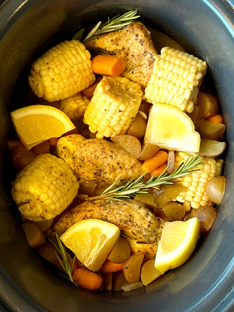 Slow Cooker Summer chicken cooked and topped with fresh lemon wedges. 