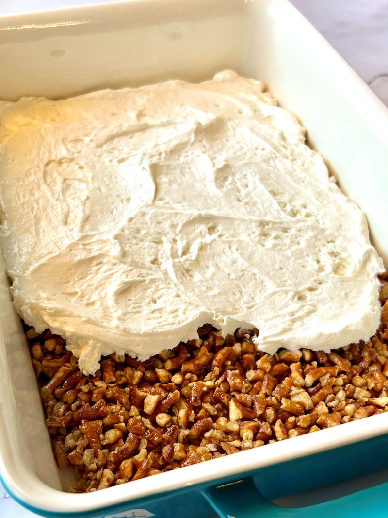 cream cheese topping spread on cooled pretzel crust.