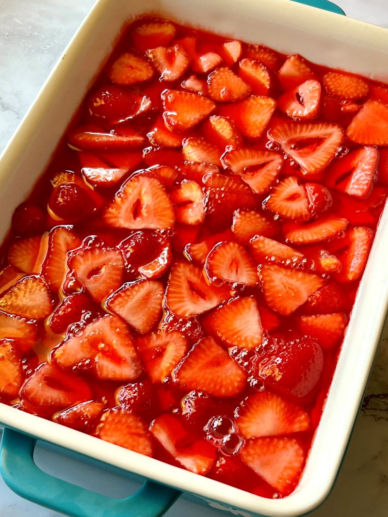 Jell-O and strawberries poured over cream cheese layer. 