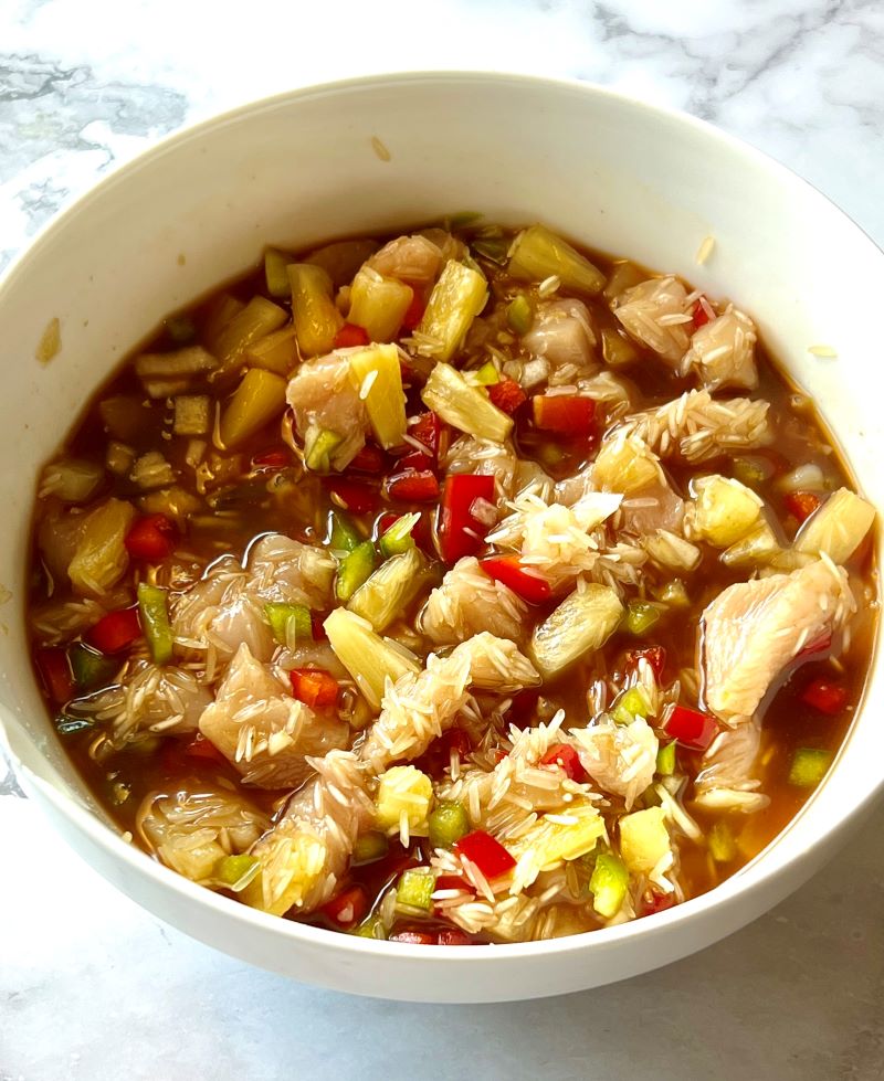 All the ingredients combined in a bowl for pineapple chicken and Rice casserole. 