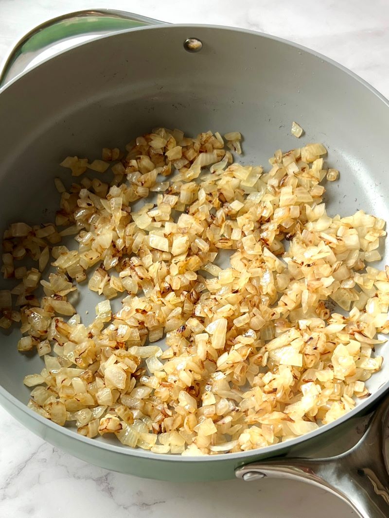 Onions sautéed in a large skillet with olive oil.