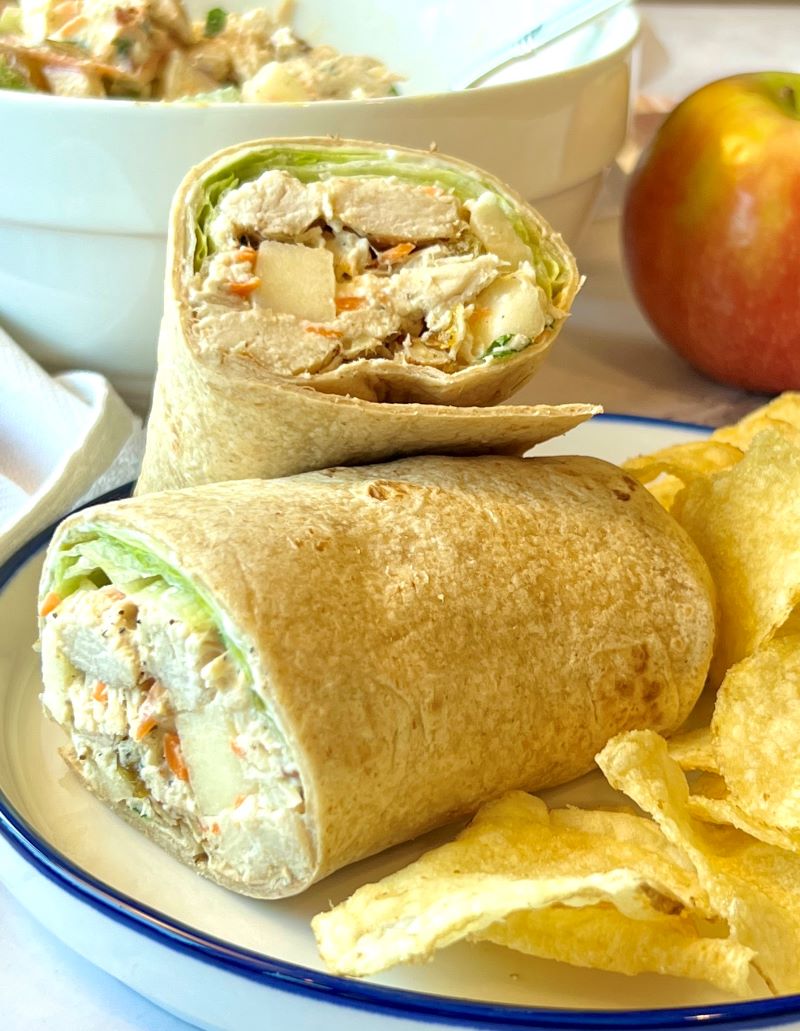 Chicken salad wrapped in a whole wheat tortilla with potato chips on the side. 