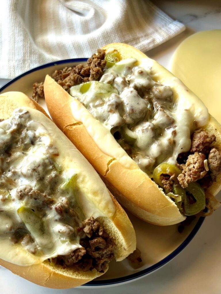 two Philly cheesesteak sandwiches with melted cheese
