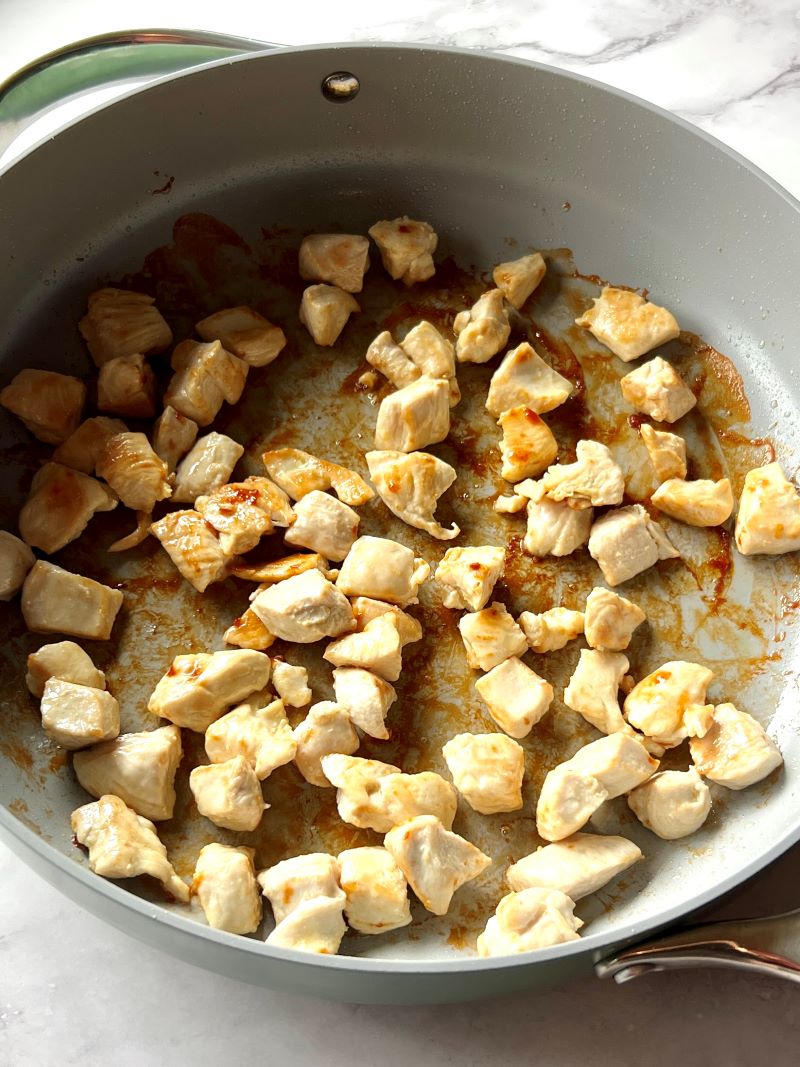 Seared chicken in a large skillet.