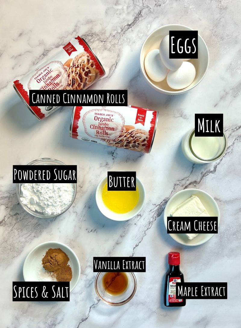 Ingredients displayed for cinnamon roll French toast casserole. 2 cans of cinnamon rolls with icing, eggs, milk, powdered sugar, butter, cream cheese, vanilla extract, cinnamon, nutmeg, and salt, and maple extract. 