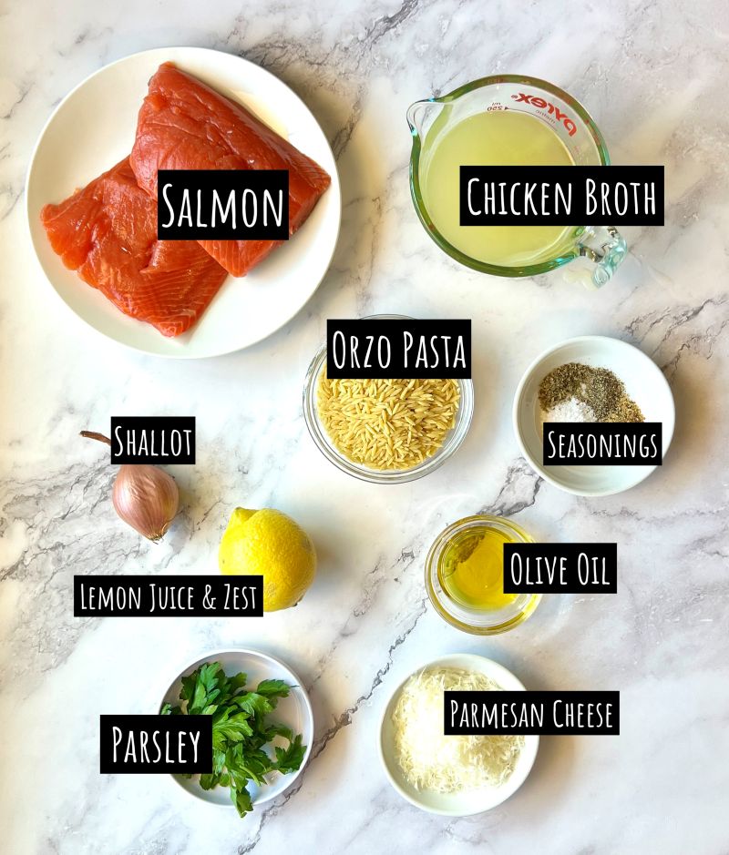 Ingredients displayed for one-skillet salmon with orzo. Salmon filets, chicken broth, orzo pasta, shallot, seasonings, lemon, olive oil, parsley, and parmesan cheese. 