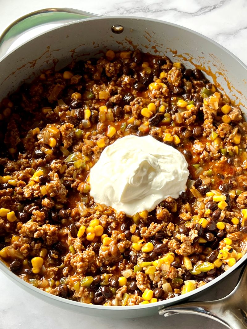 Ground beef mixture combined with enchilada sauce, black beans, roasted corn, and sour cream.