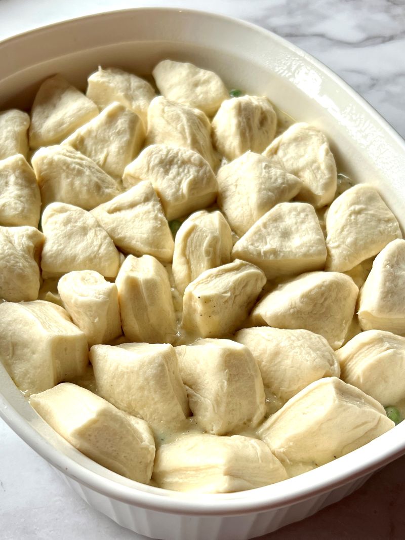 Biscuit pieces on top of the creamy chicken mixture in baking dish. 