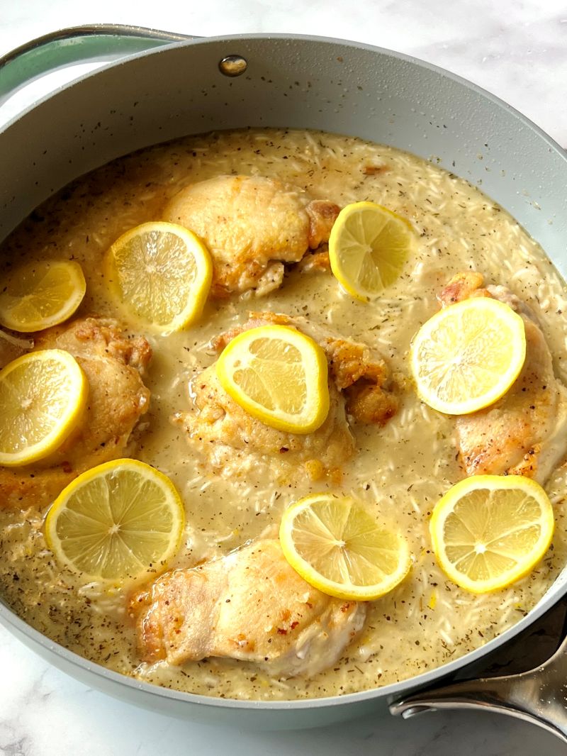 Chicken back in the pan with rice mixture and topped with lemon slices.
