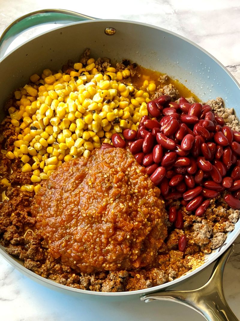 Cooked ground beef mixed with kidney beans, roasted corn, salsa, taco seasoning, chicken broth, salt and pepper.