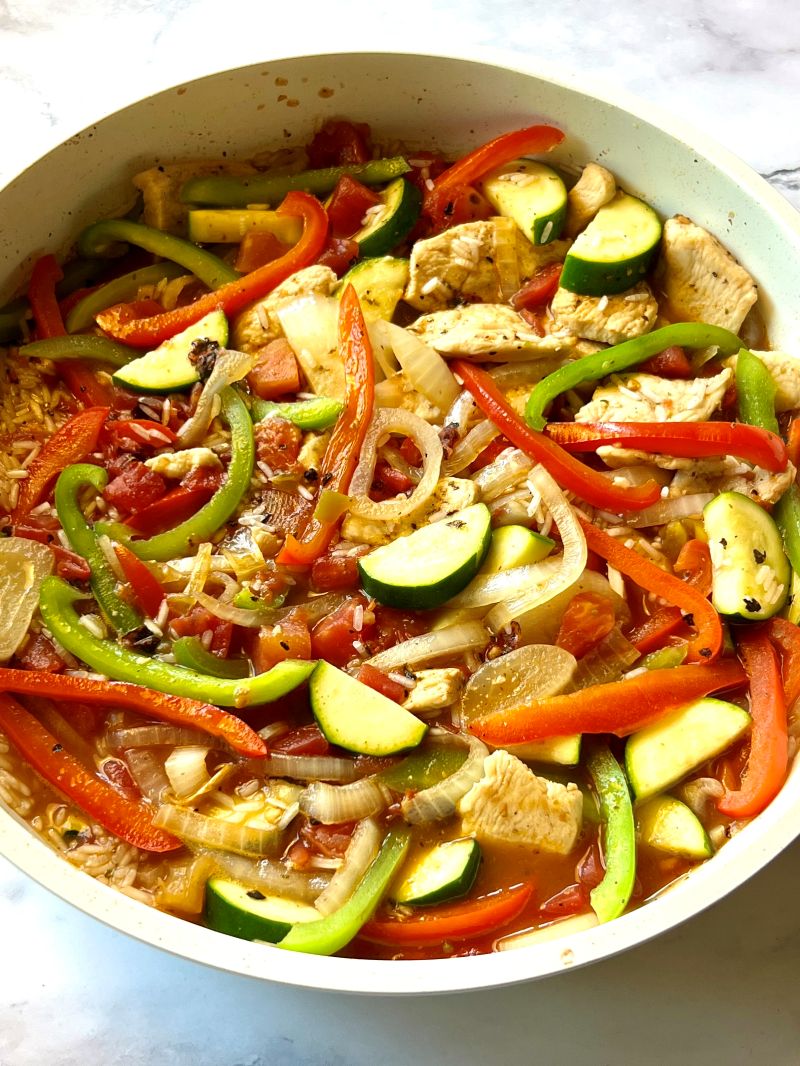 Veggies combined with chicken, broth, rice, Rotel, and fajita seasoning. 