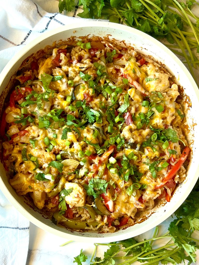 Chicken fajita casserole baked and topped with cheese, cilantro, and green onion. 