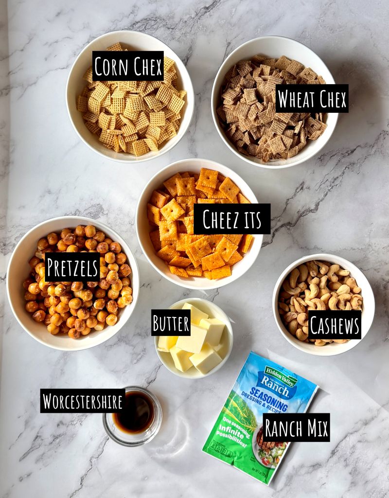 Ingredients displayed for Ranch slow cooker Chex mix. Corn Chex, wheat Chex, cheez its, pretzels, cashews, butter, ranch seasoning mix, Worcestershire sauce. 