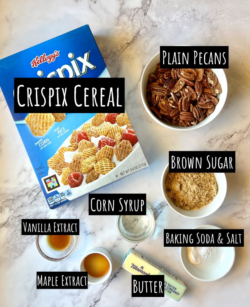ingredients displayed for maple pecan snack mix. Crispix cereal, plain pecans, brown sugar, corn syrup, vanilla extract, maple extract, baking soda, salt, and butter.