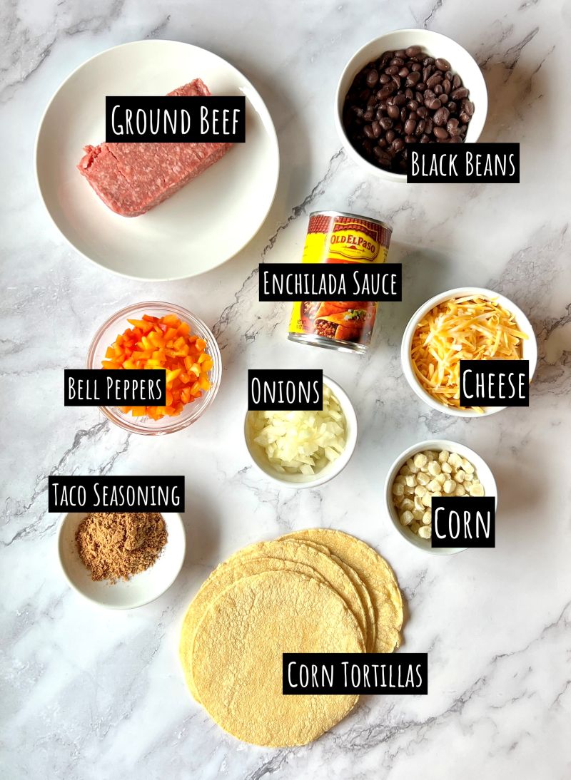 Ingredients displayed for beef enchilada casserole. Ground beef, black beans, enchilada sauce, bell peppers, onions, cheese, corn, taco seasoning, and corn tortillas.