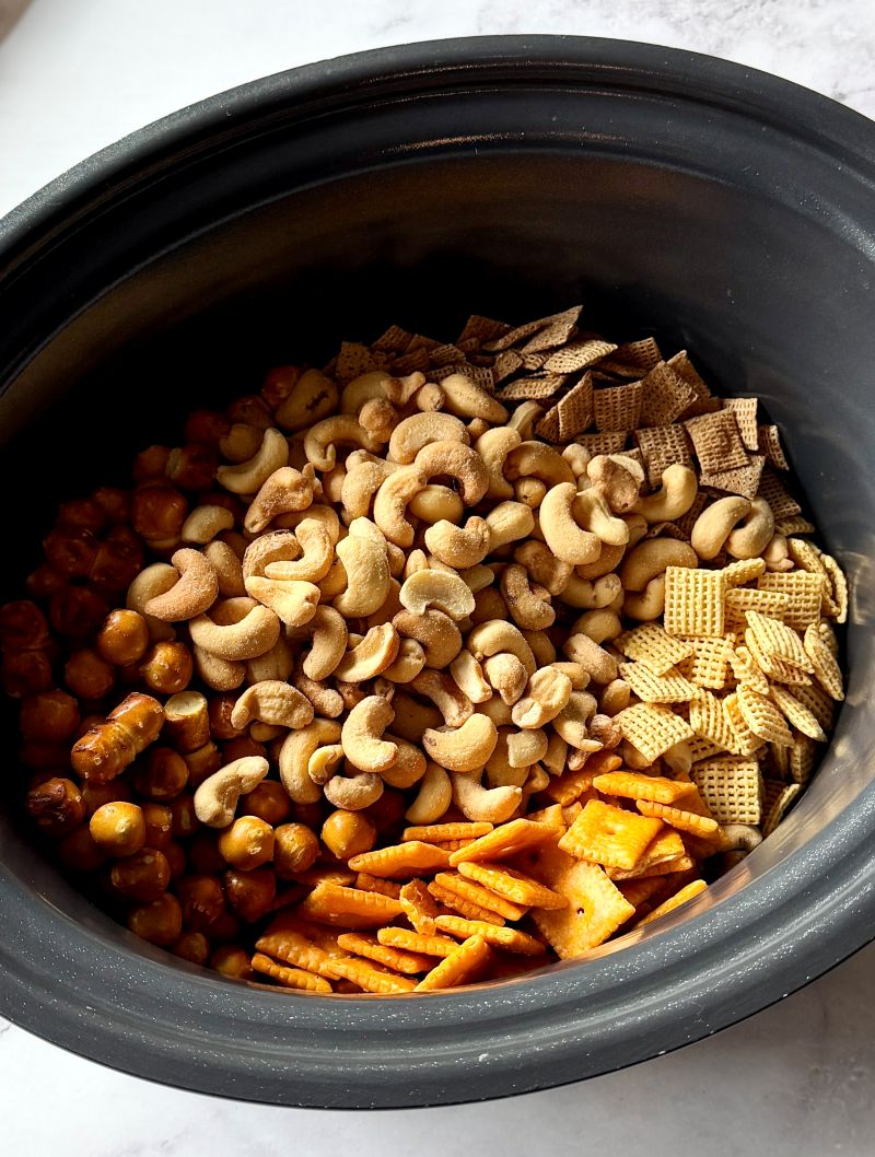 Crunchy ingredients for Chex mix in a large slow cooker