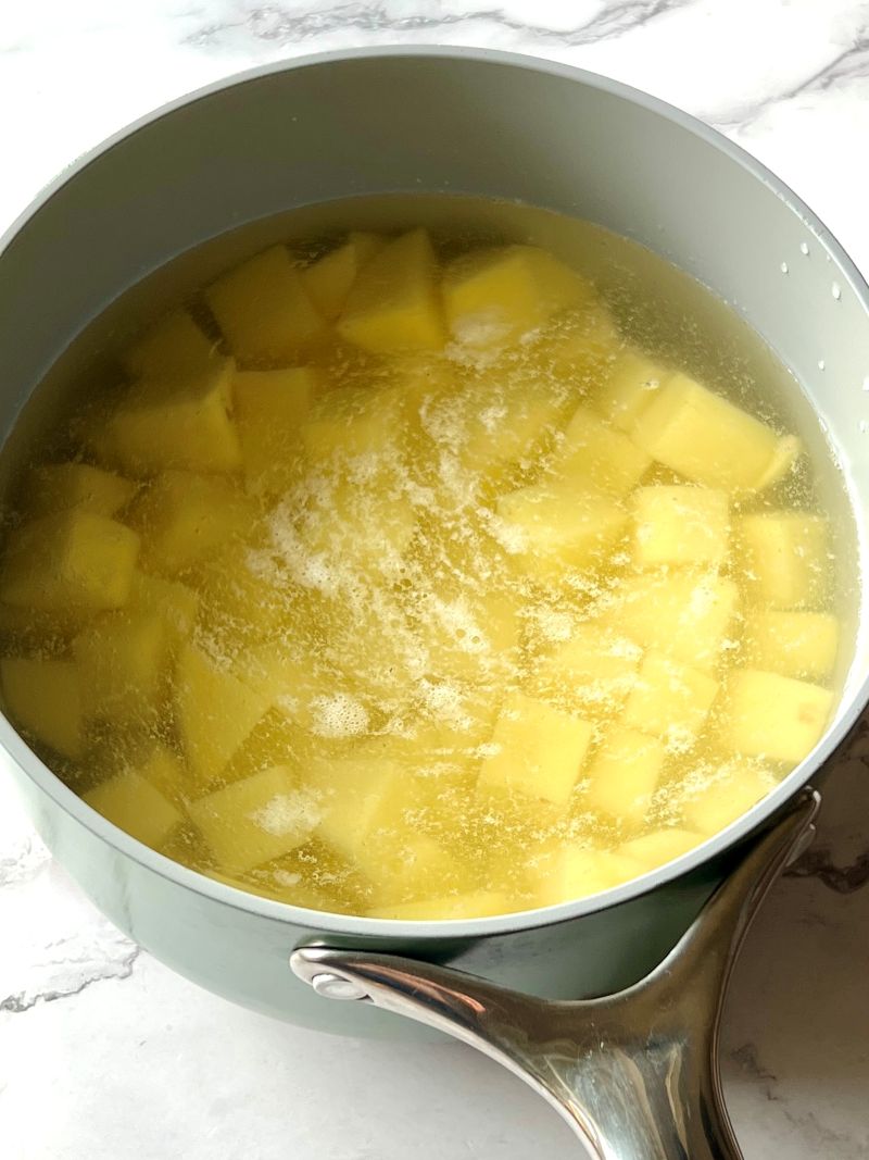 Potatoes in water in a pot.