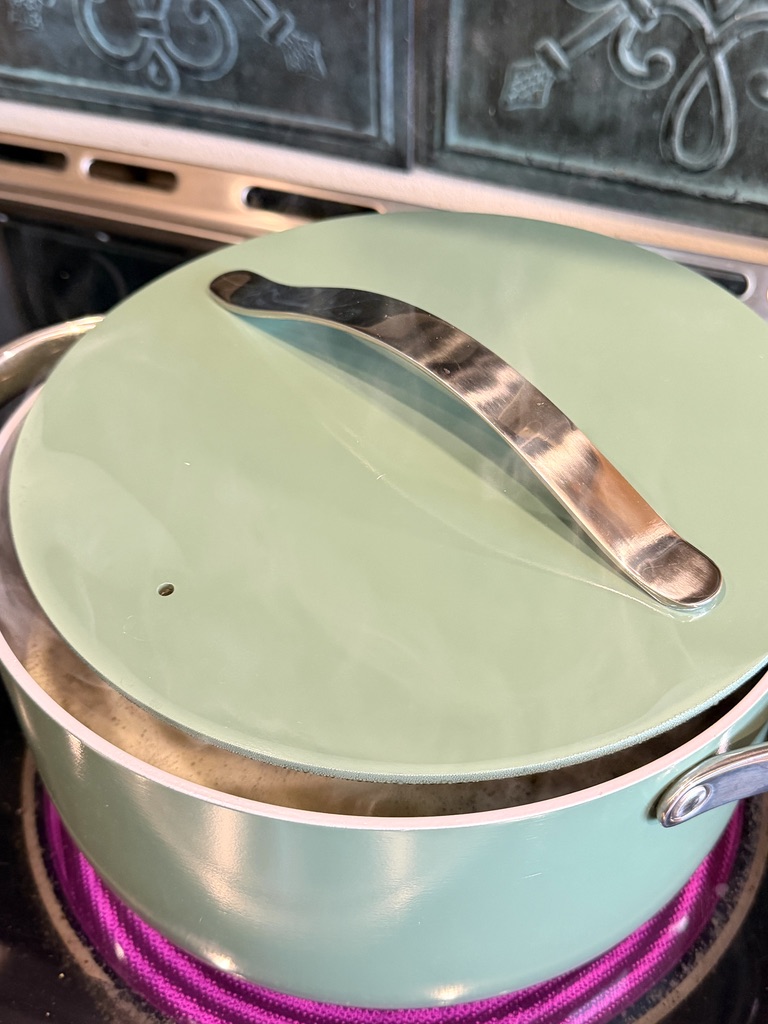 Split pea soup cooking on the stove with the lid on partially.