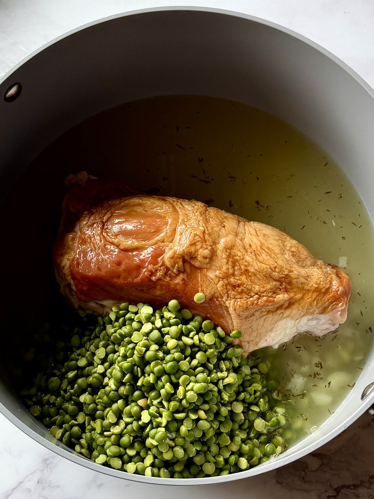 Ham shank and dry split peas added to the soup pot.
