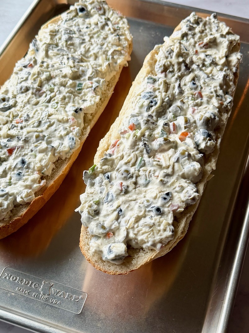 Cheese and olive mixture spread on French bread halves.