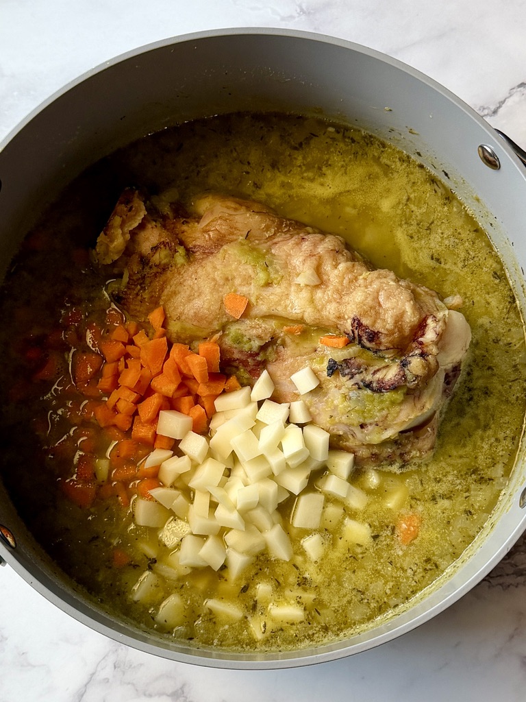 Potatoes and carrots added to the soup pot.