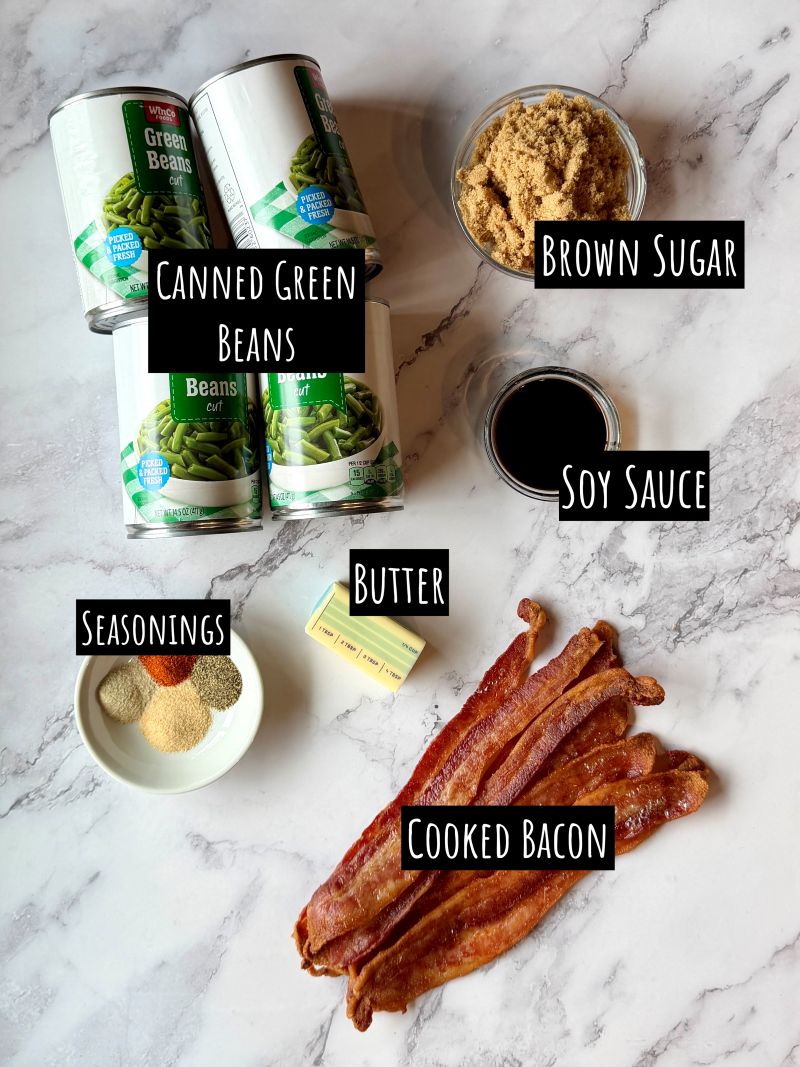 Ingredients displayed for The best crack green beans. Canned green beans, brown sugar, soy sauce, butter, cooked bacon strips, garlic powder, onion powder, paprika, salt and pepper. 