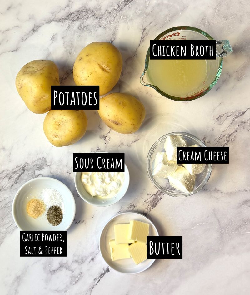 Ingredients displayed for crockpot mashed potatoes with cream cheese. Yukon gold potatoes, chicken broth, cream cheese, sour cream, butter, and seasonings. 